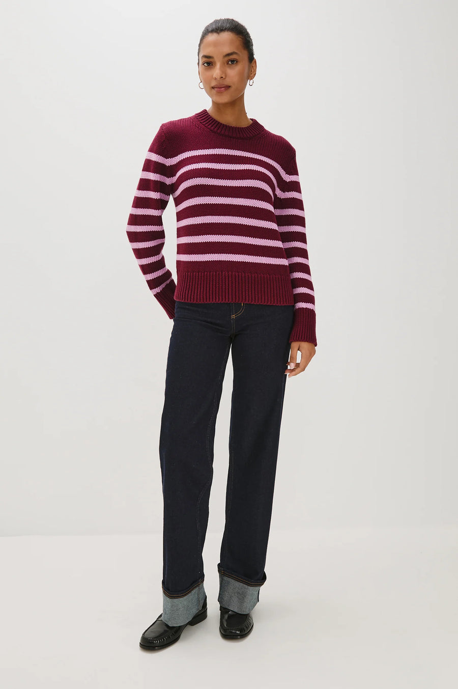 Woman wearing a maroon and pink striped sweater 