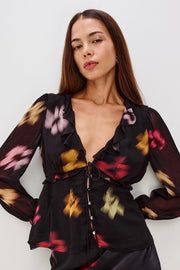 woman wearing a black top with blurred floral design