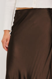 close up of woman wearing a brown satin skirt