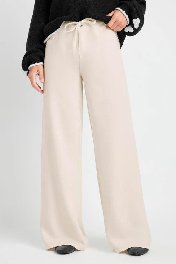 Beige wide-leg pants worn by a person on a white background