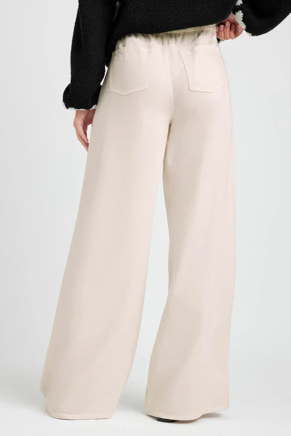 Beige wide-leg pants worn by a person on a white background