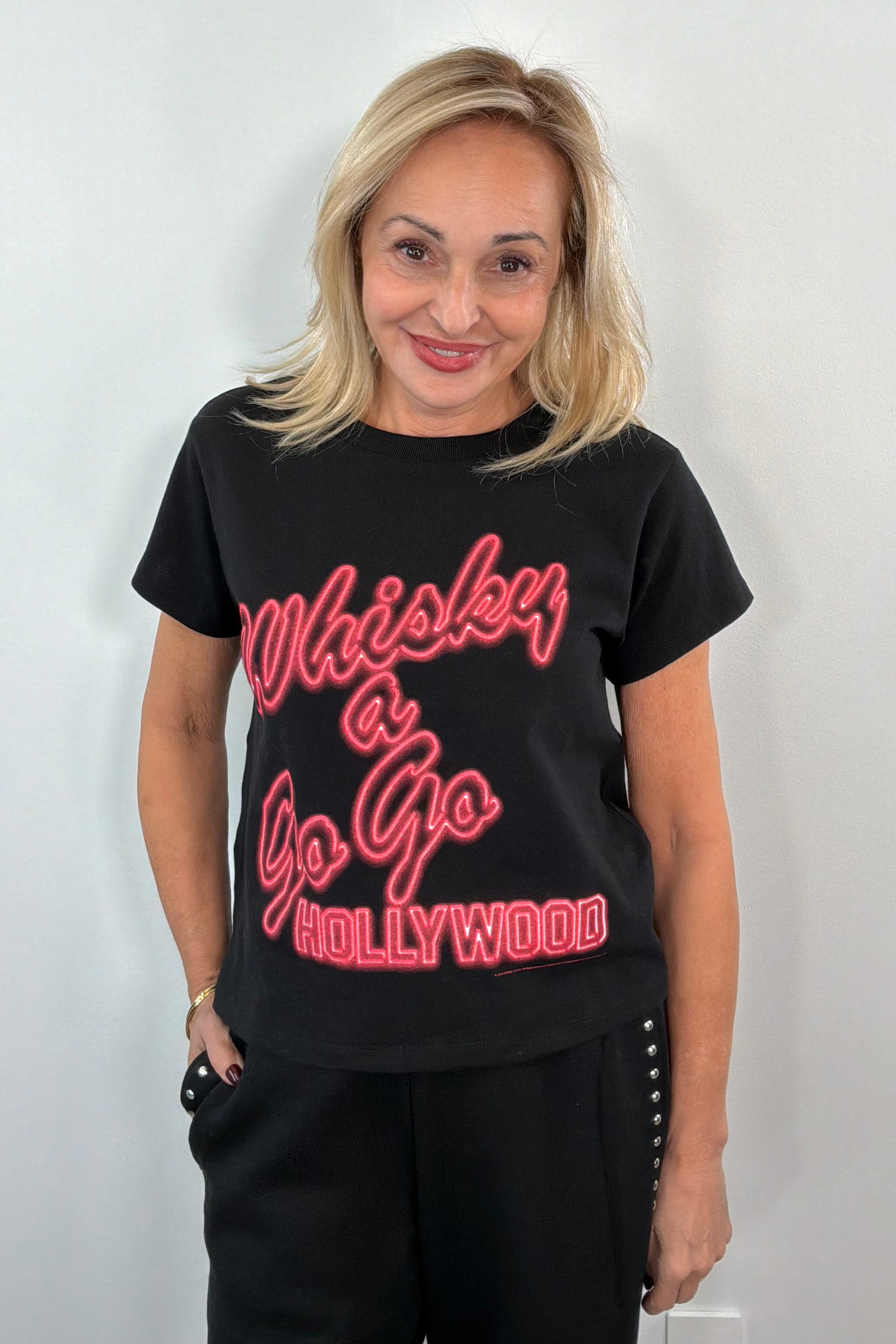Woman wearing a black graphic t-shirt with red text