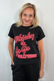 Woman wearing a black graphic t-shirt with red text