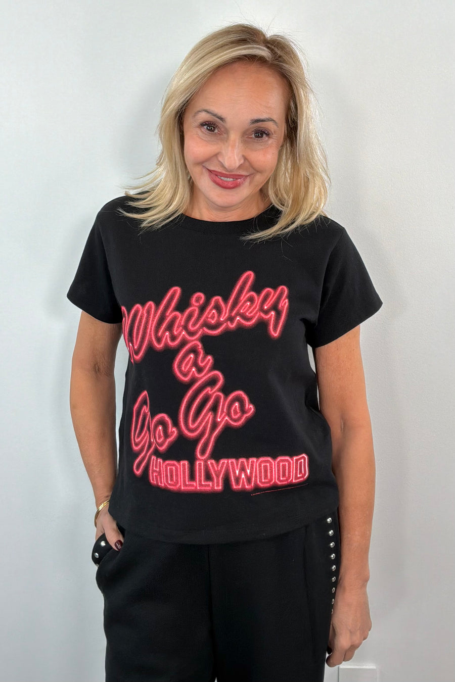Woman wearing a black graphic t-shirt with red text