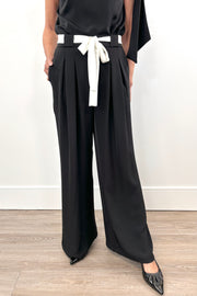 woman wearing a black pat with white shash belt 