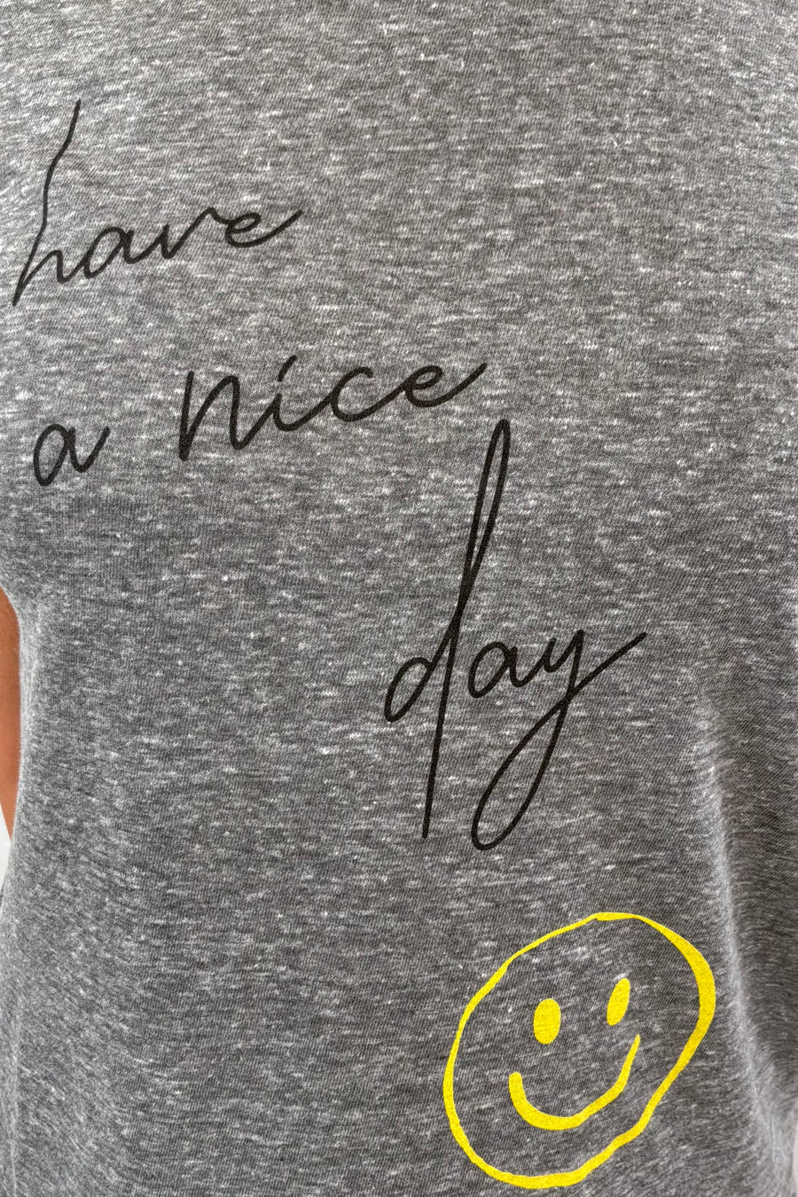 close-up of a gray t-shirt with 'Have a nice day' text and smiley face design