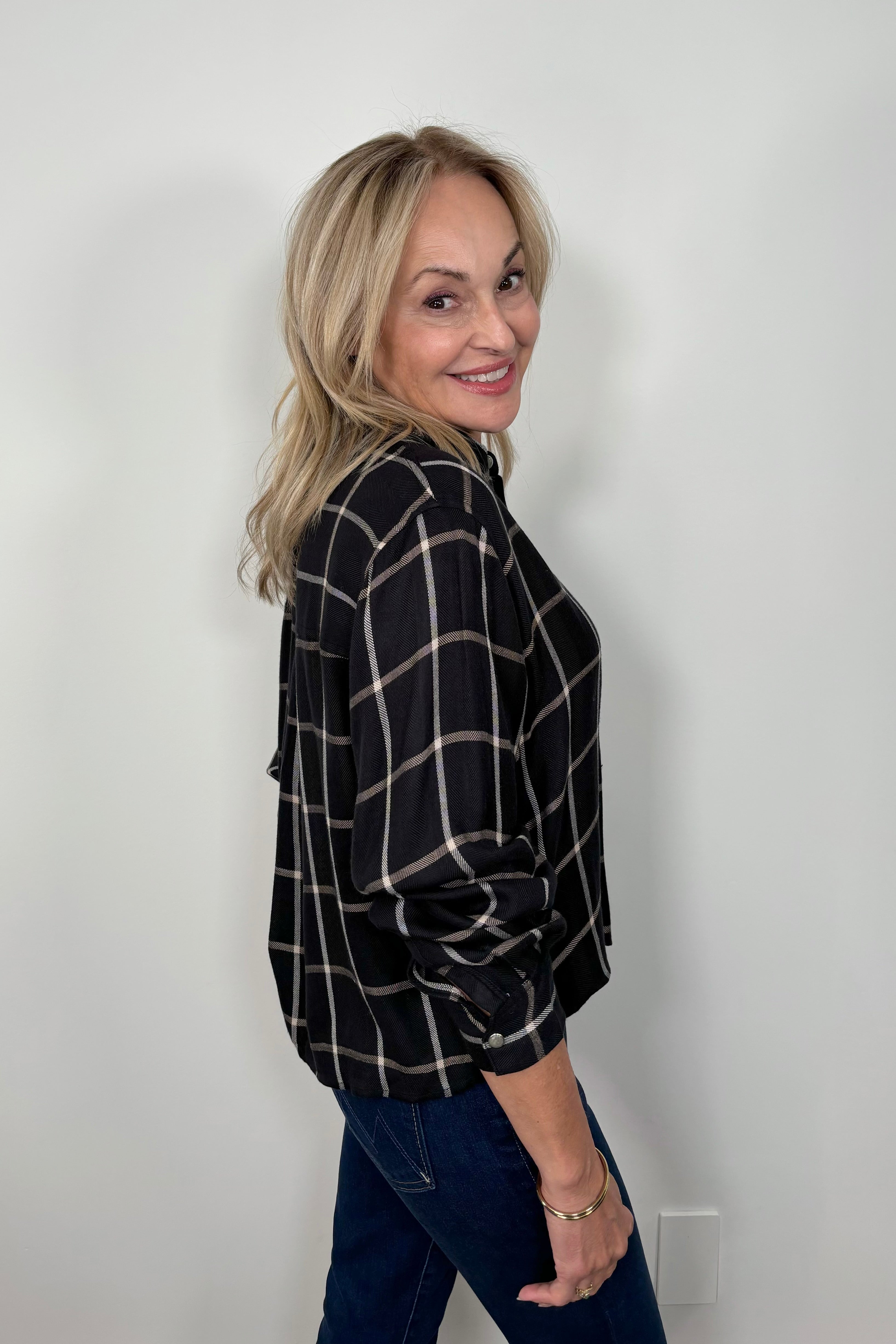 side view of woman wearing  a black and white plaid shirt 