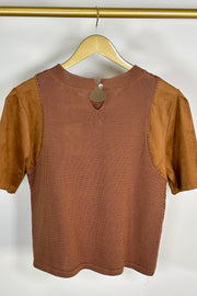 Back view of woman wearing a mixed crochet and suede leather short sleeve top