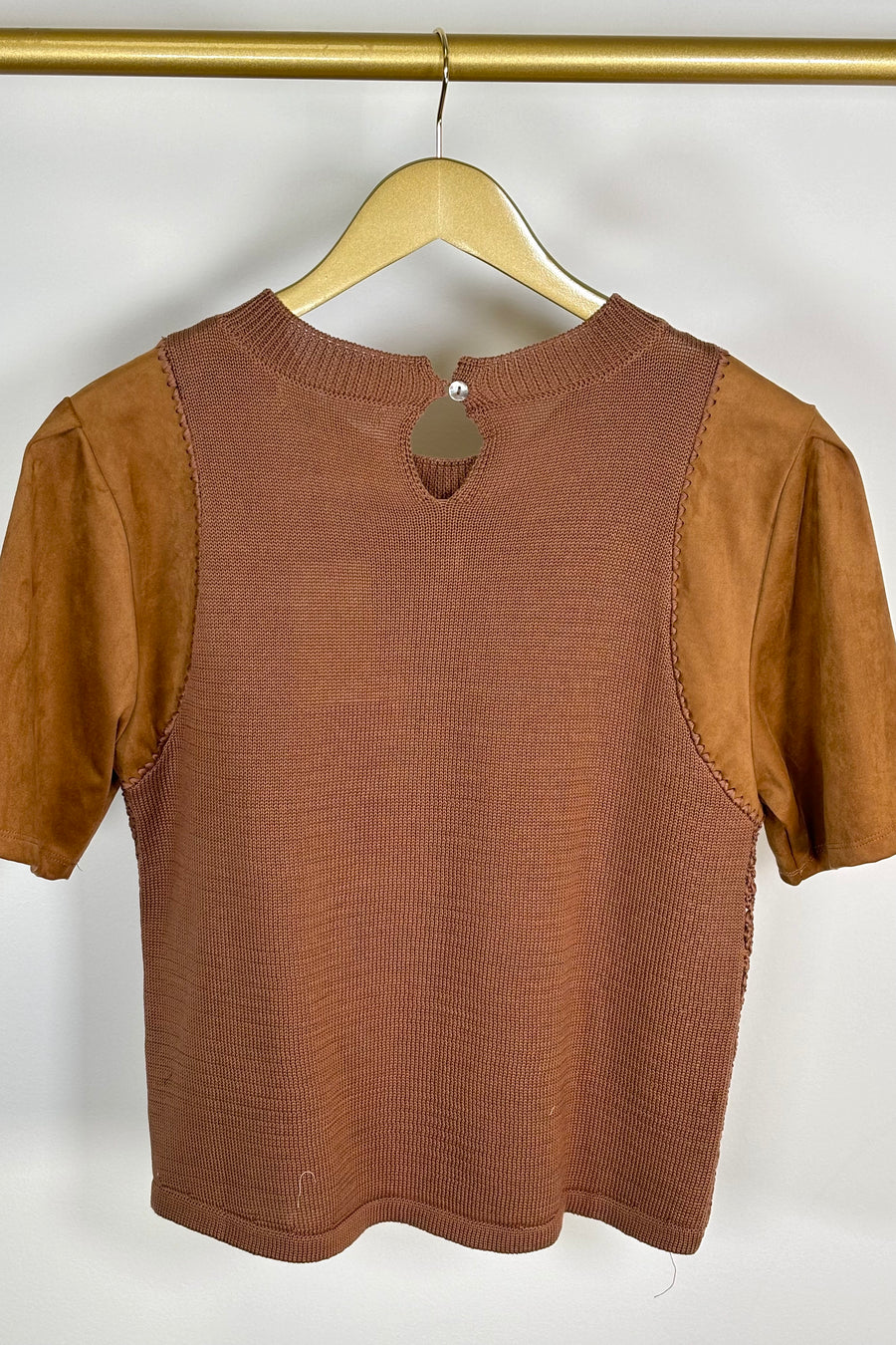 Back view of woman wearing a mixed crochet and suede leather short sleeve top