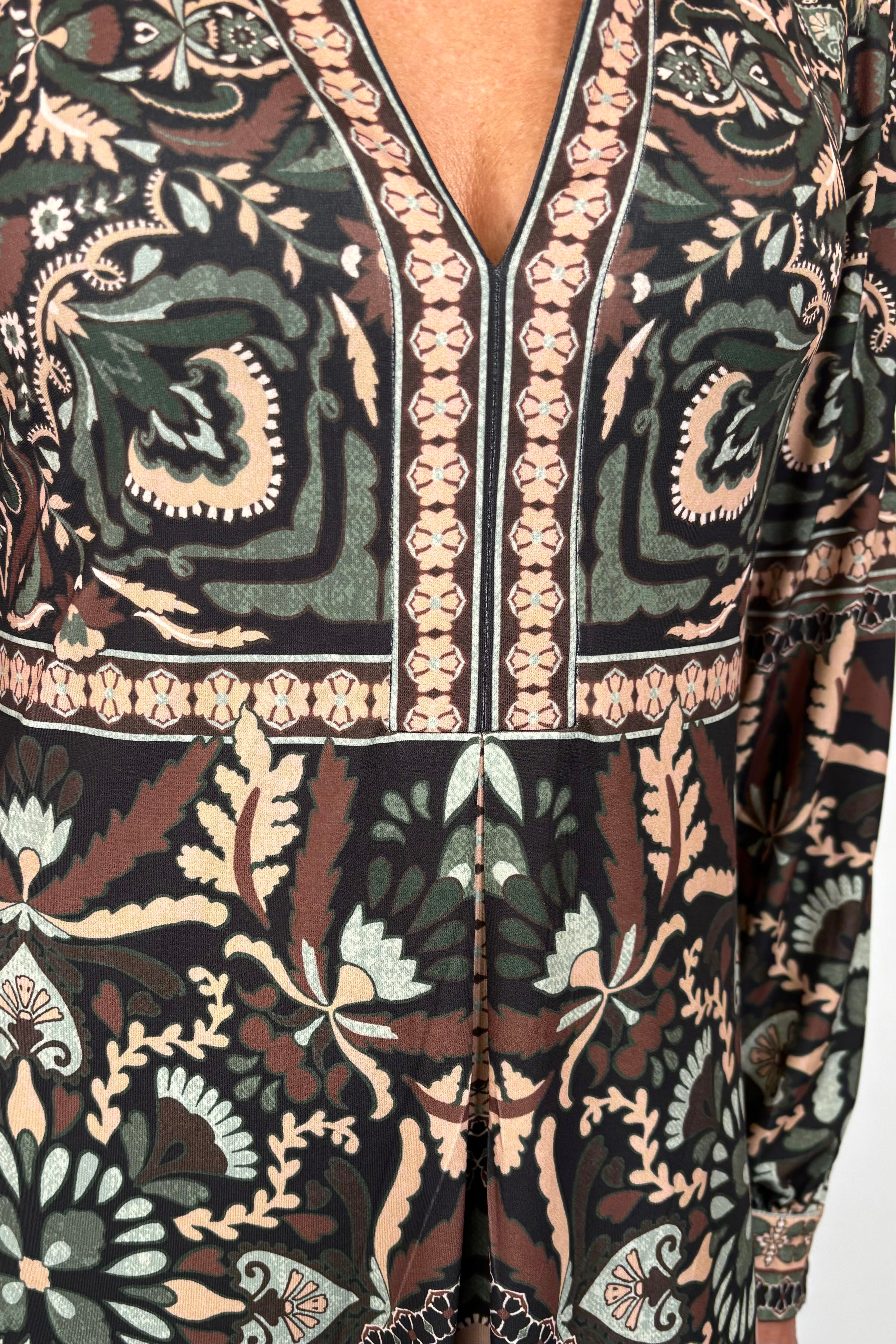 close-up of a short green long sleeve patterned dress