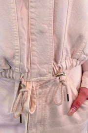 Close-up of a light pink jacket with drawstrings 