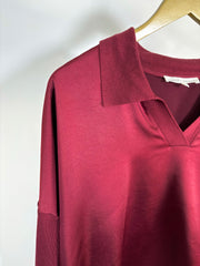 Close-up of the collar of a red wine long sleeve satin top