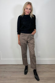 Front view of woman wearing a pale brown pant with a black long sleeve top