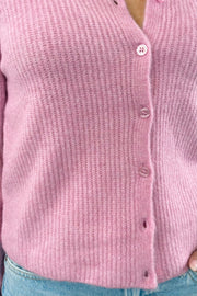 Close up of Woman wearing a pink ribbed cardigan