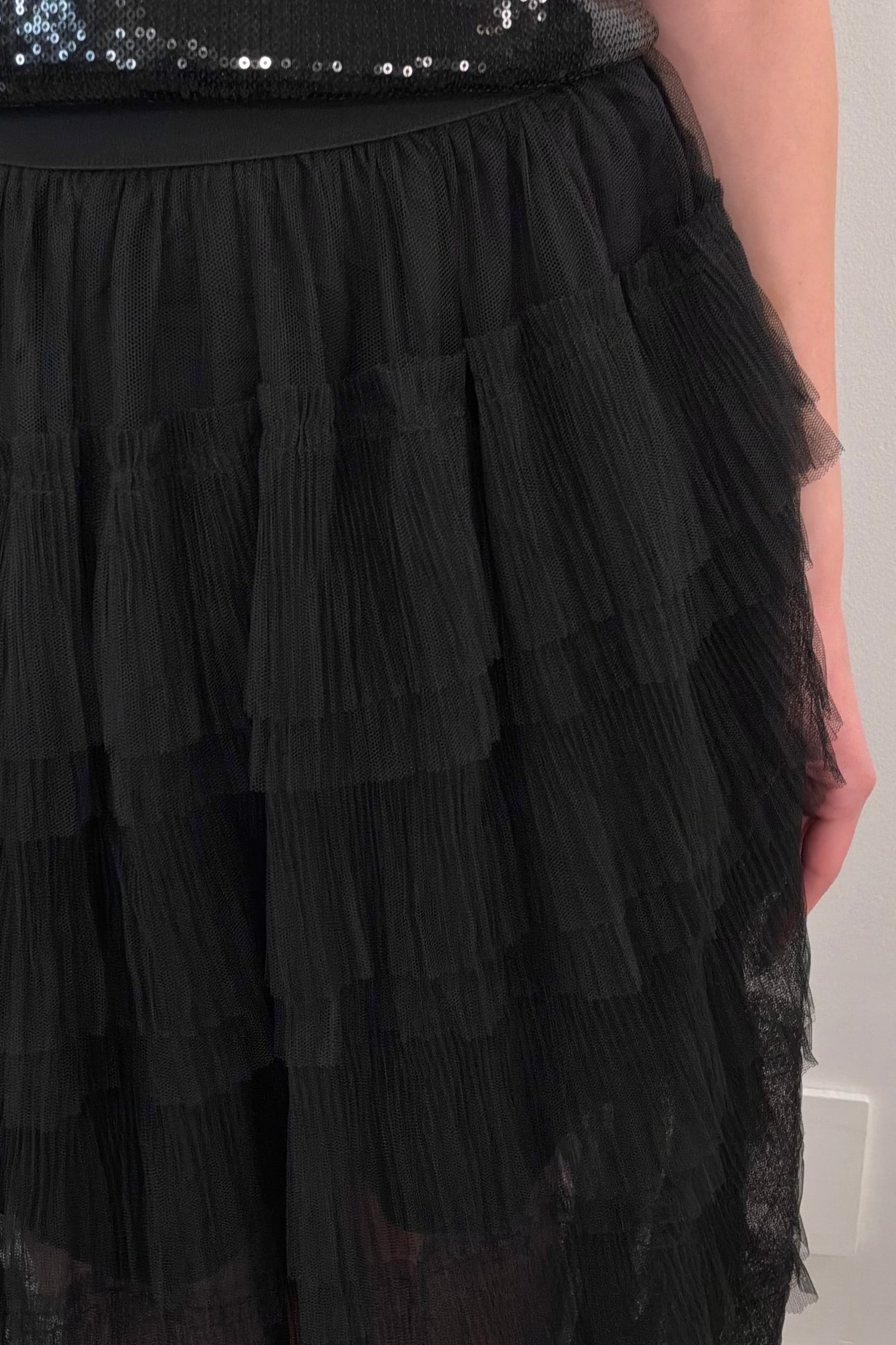 close-up of a black tiered tulle midi skirt