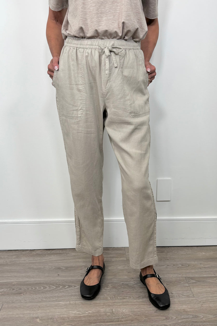 Front view of woman wearing a cool beige straight pant with detailing on the side