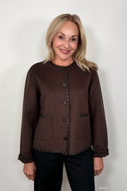 Front view of woman wearing a buttoned up brown wool with whipstitch detailing
