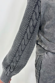 Close-up of a gray pullover sweatshirt with detailing on the sleeves
