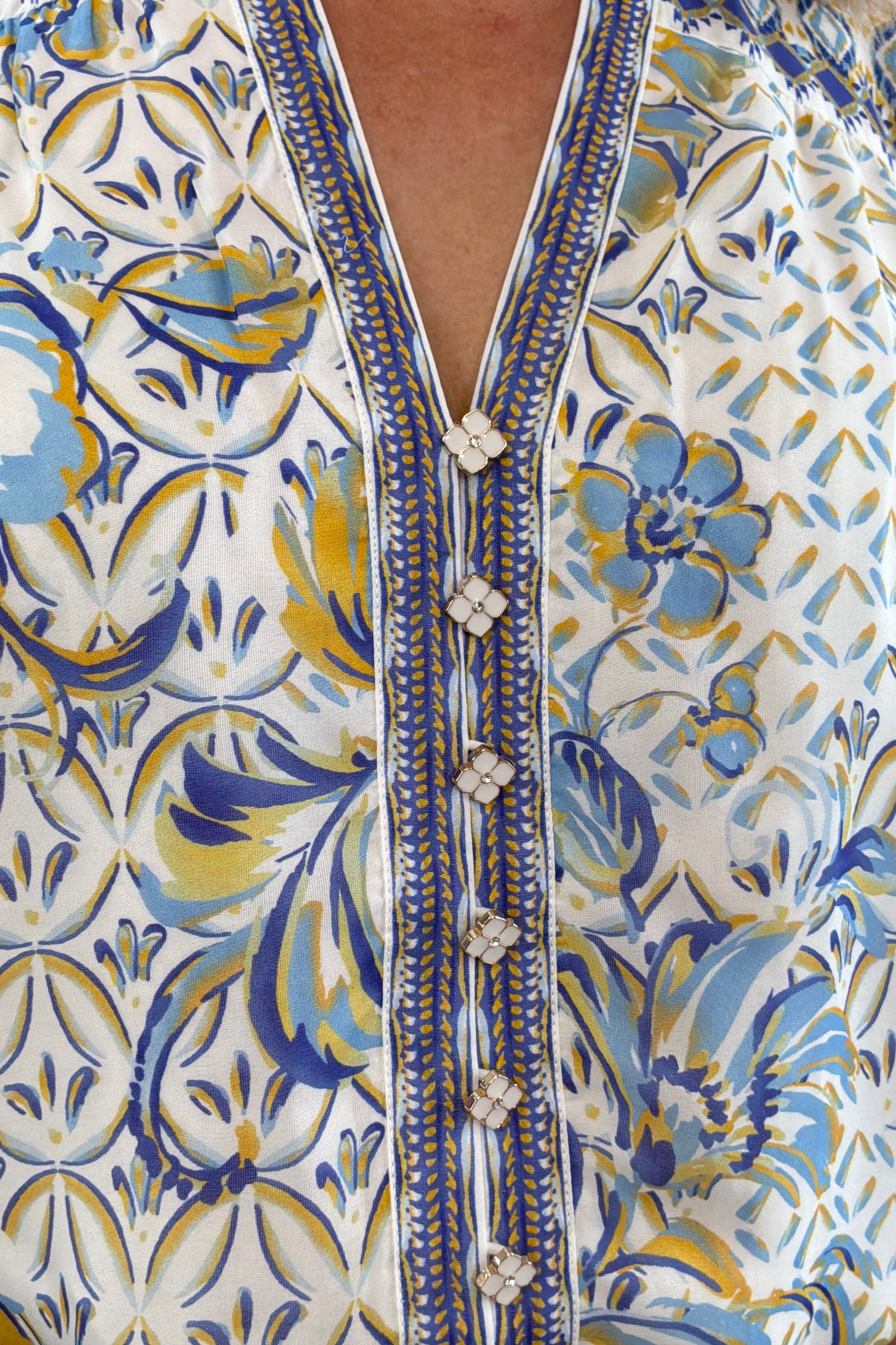 Woman wearing a patterned blue blouse 