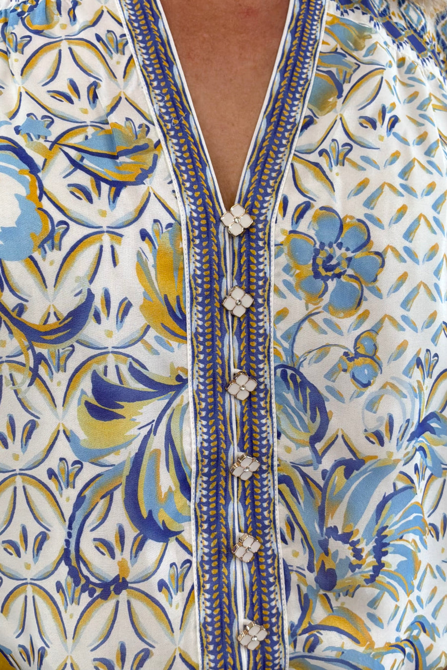 Woman wearing a patterned blue blouse 