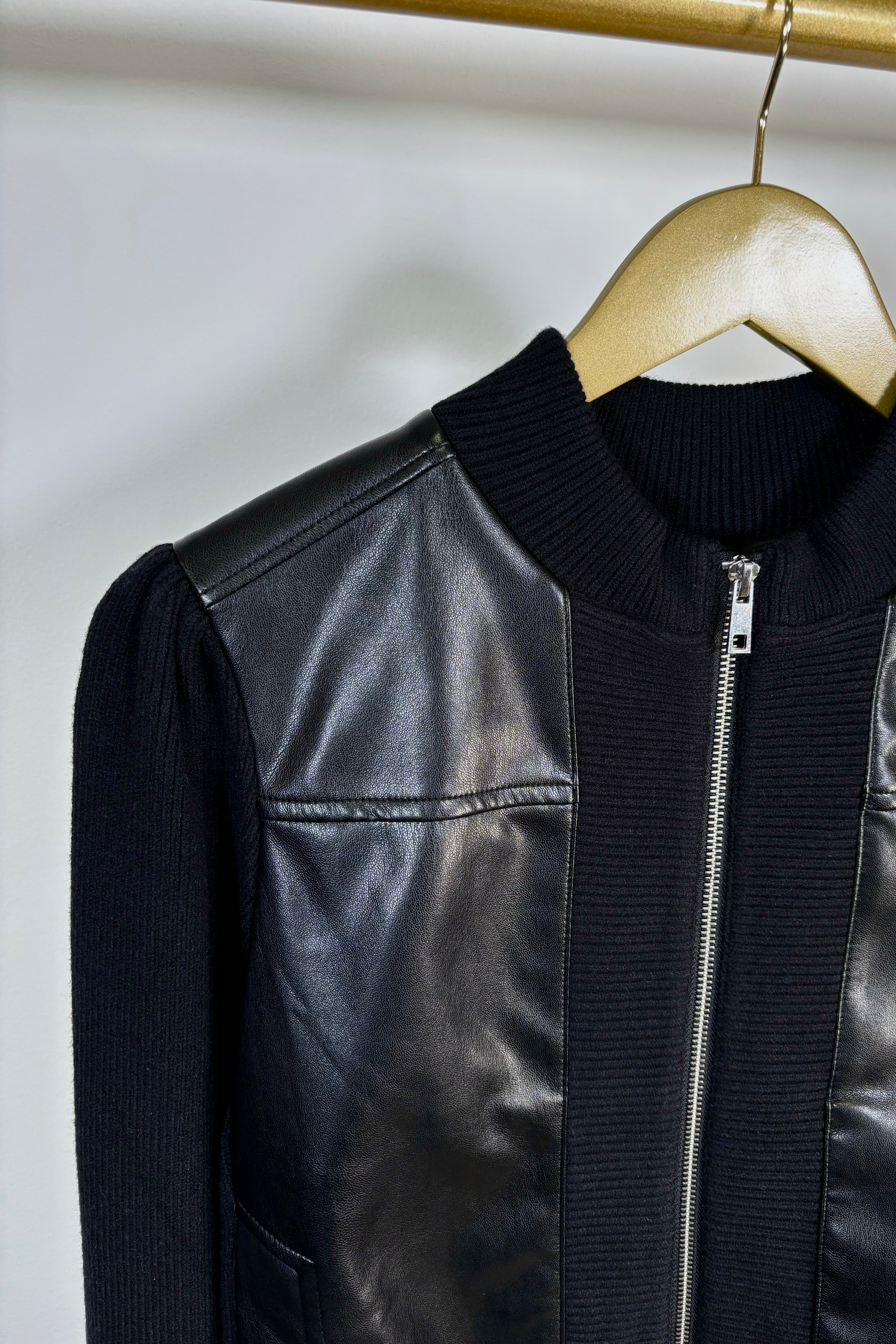 Close-up of the right shoulder of a black coloured mix media bomber jacket 
