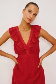 Woman wearing a red linen maxi dress with a ruffled V-neckline