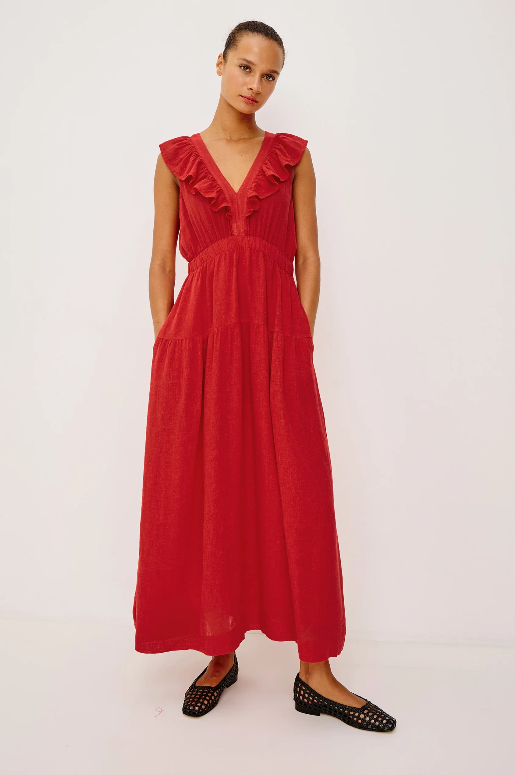 Woman wearing a red linen maxi dress with a ruffled V-neckline
