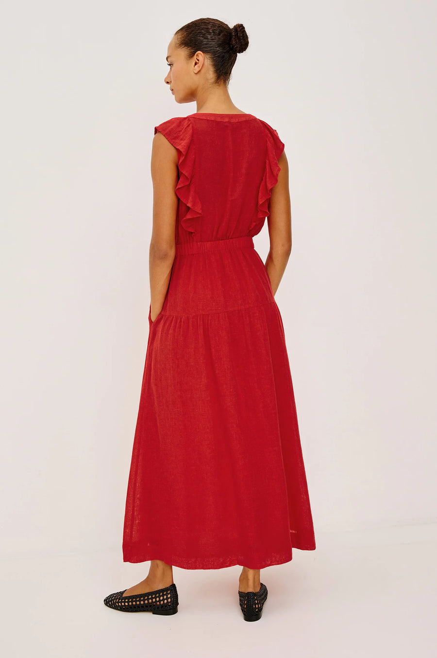 Woman wearing a red linen maxi dress with a ruffled V-neckline