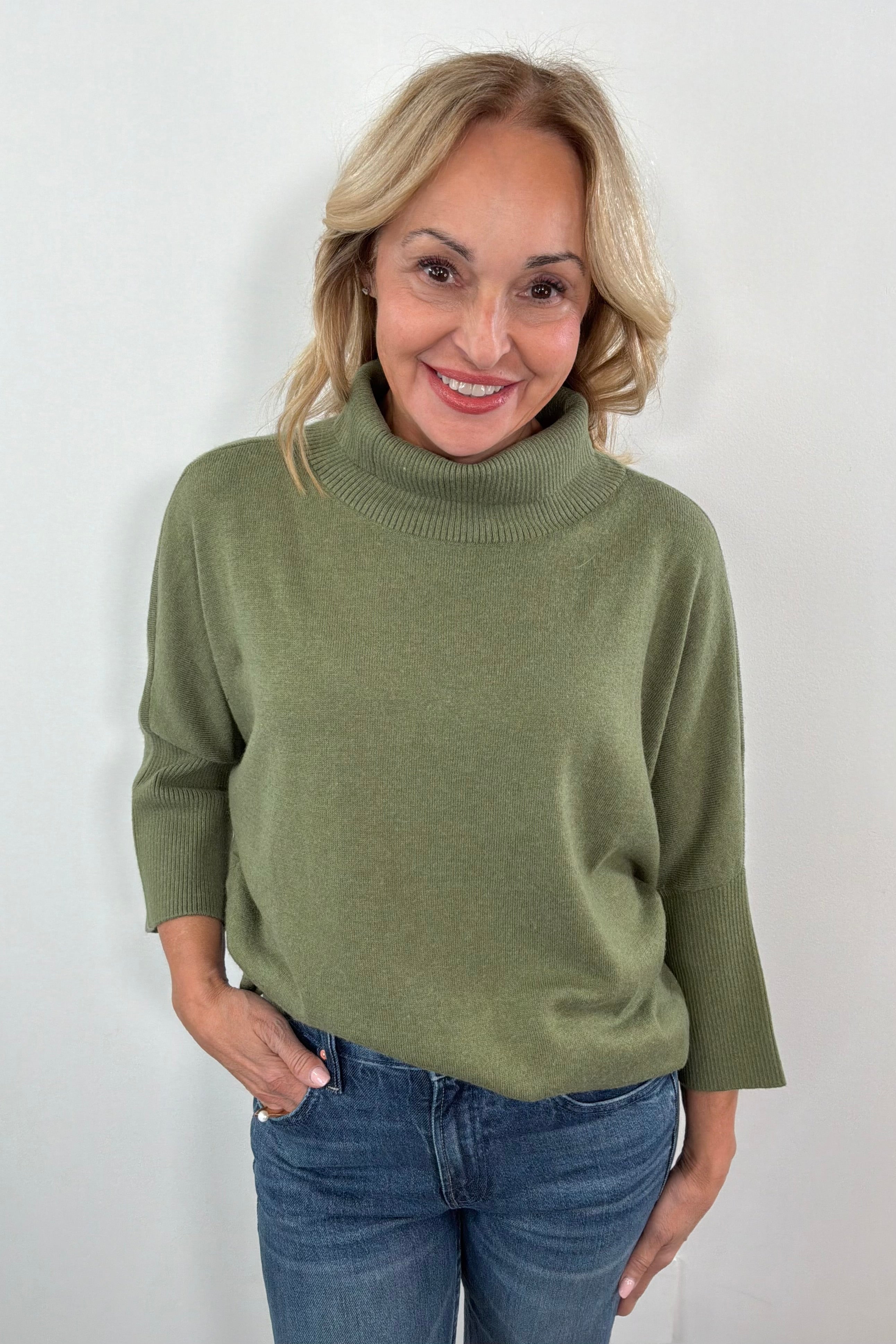 woman wearing a half sleeve green turtleneck sweater