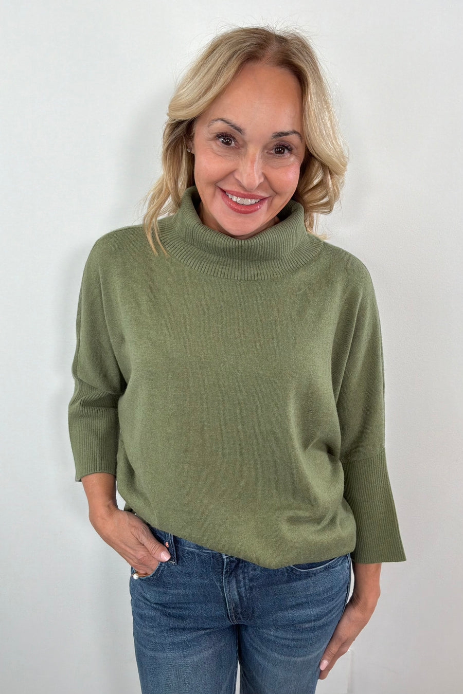 woman wearing a half sleeve green turtleneck sweater