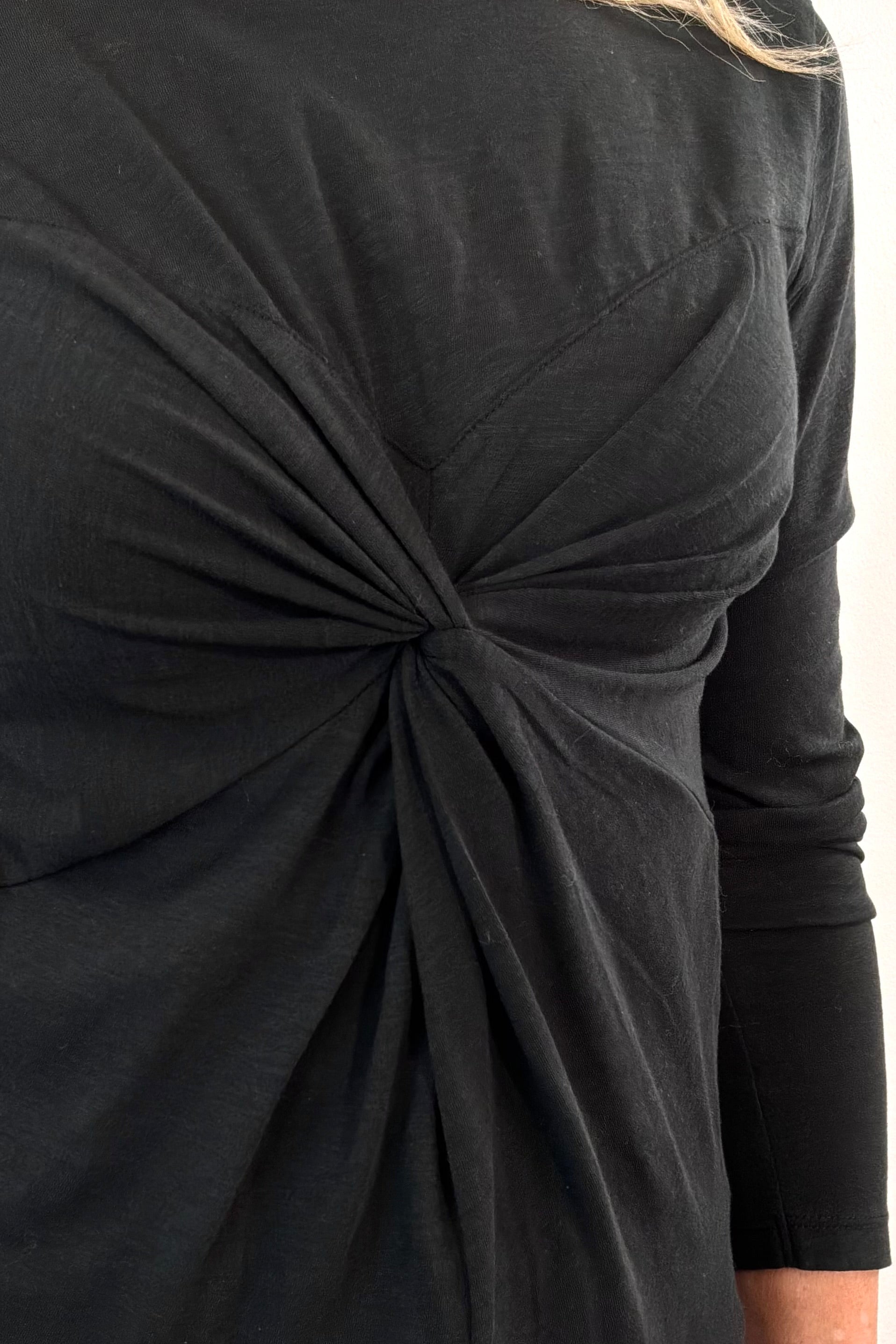 close-up of a black long-sleeve top with a knot detail 