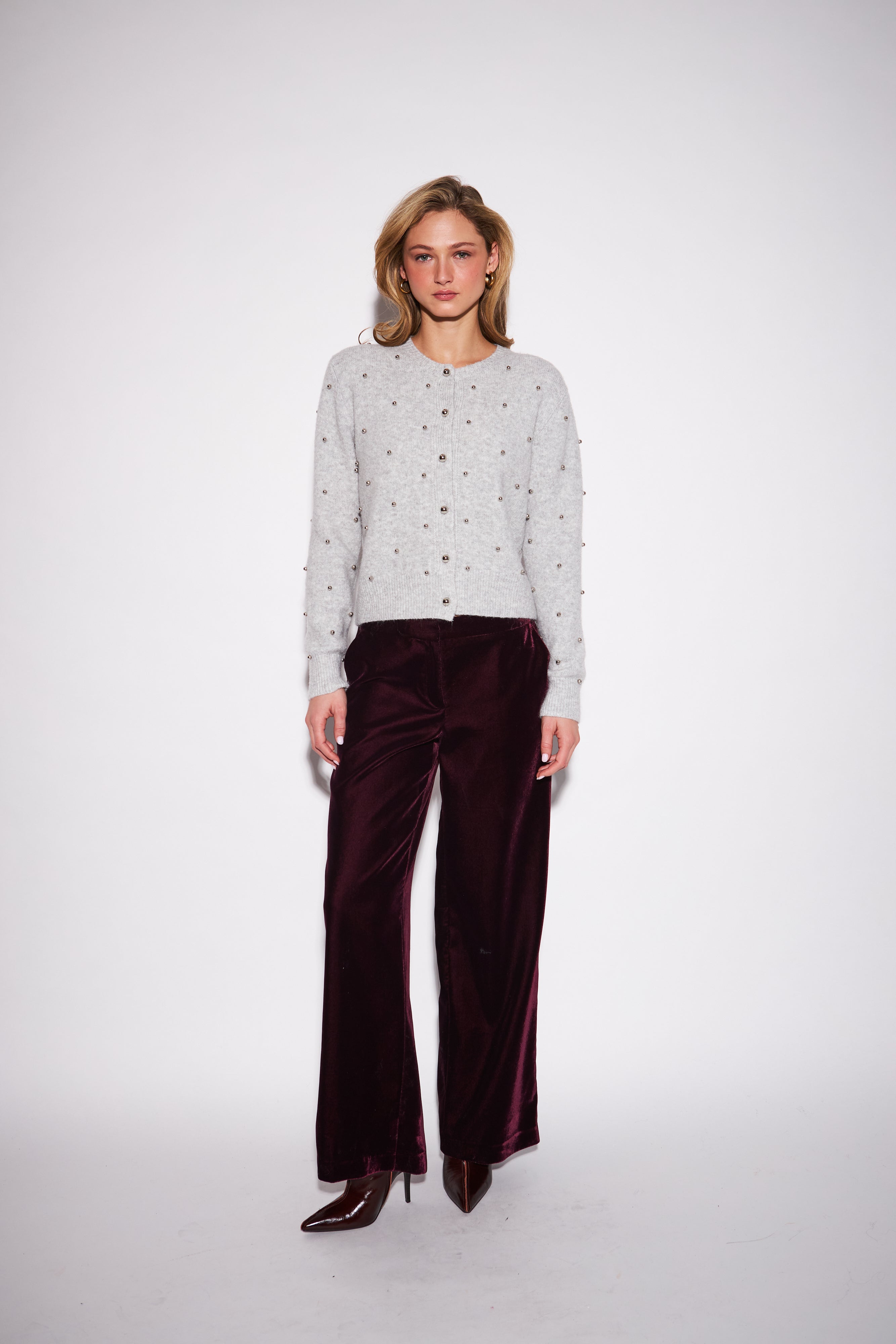 model wearing a light grey knit sweater embellished with small silver studs
