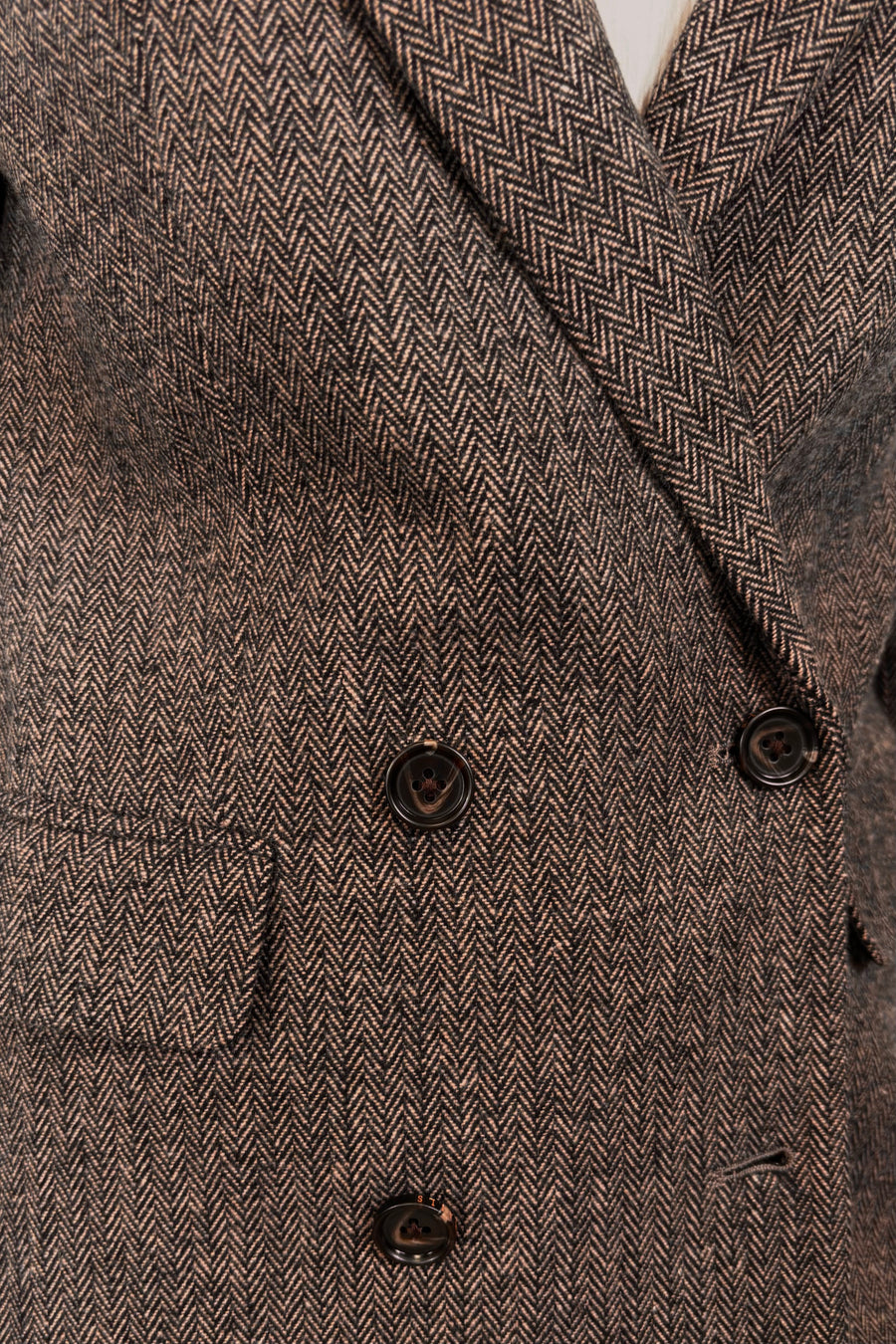 Close-up of a cool-toned brown herringbone blazer