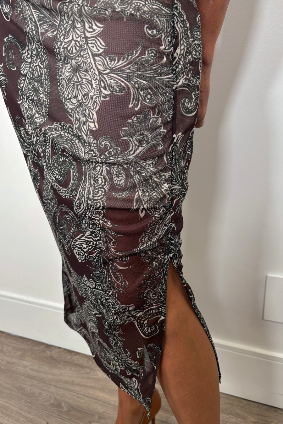 Close-up of the slit of a long sleeve mock neck mesh dress