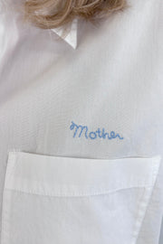 Close up of a woman wearing a cropped white button up collared shirt with a side pocket