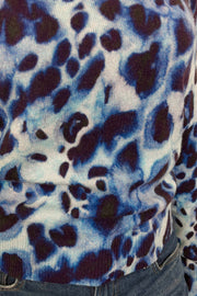 Zoom in of a woman wearing a blue watercolour animal print 100% cashmere long sleeve sweater