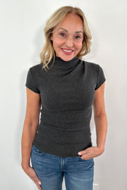 wearing a gray drape neck short sleeve top