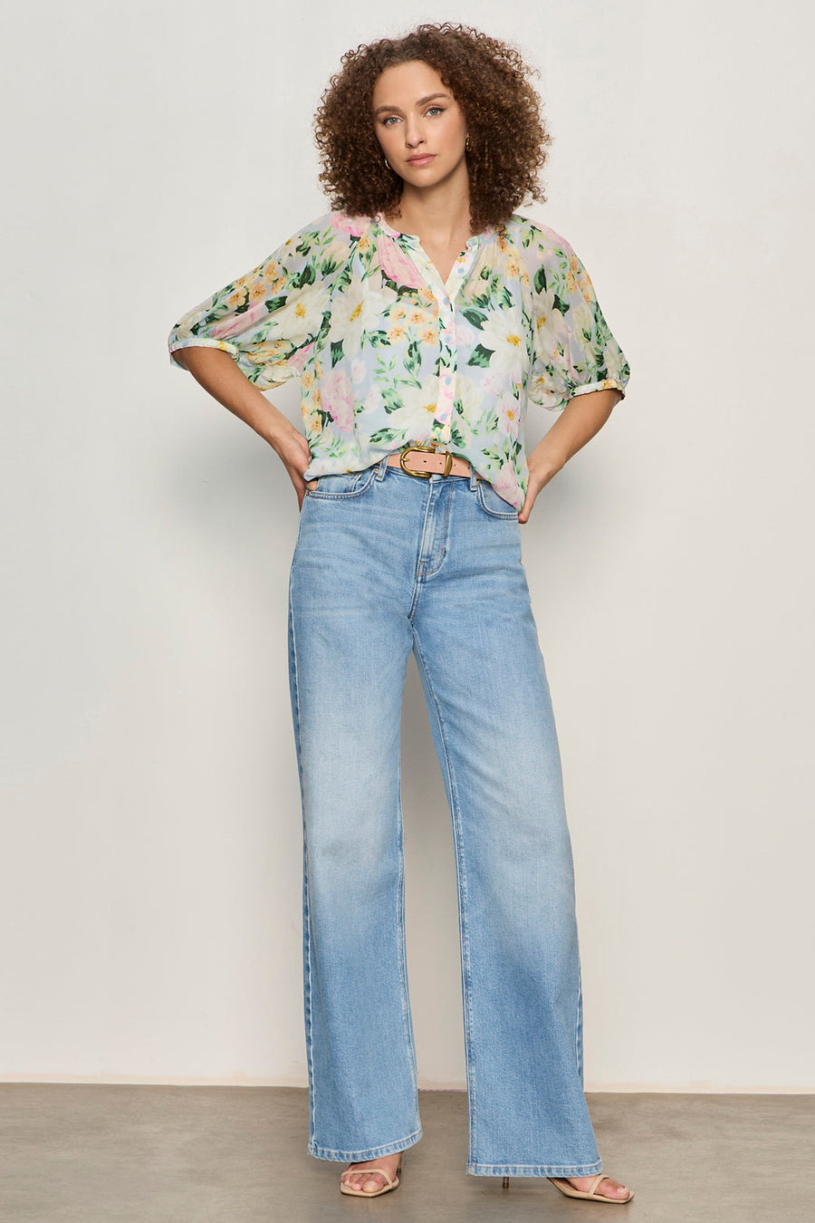 woman wearing a half sleeve floral print sheer button down blouse