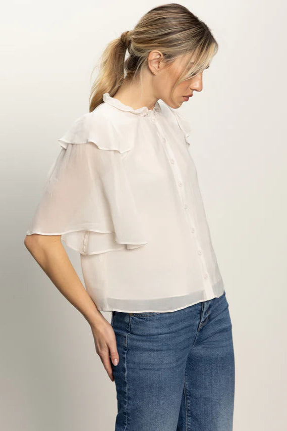 Side view of woman wearing an oat coloured light blouse