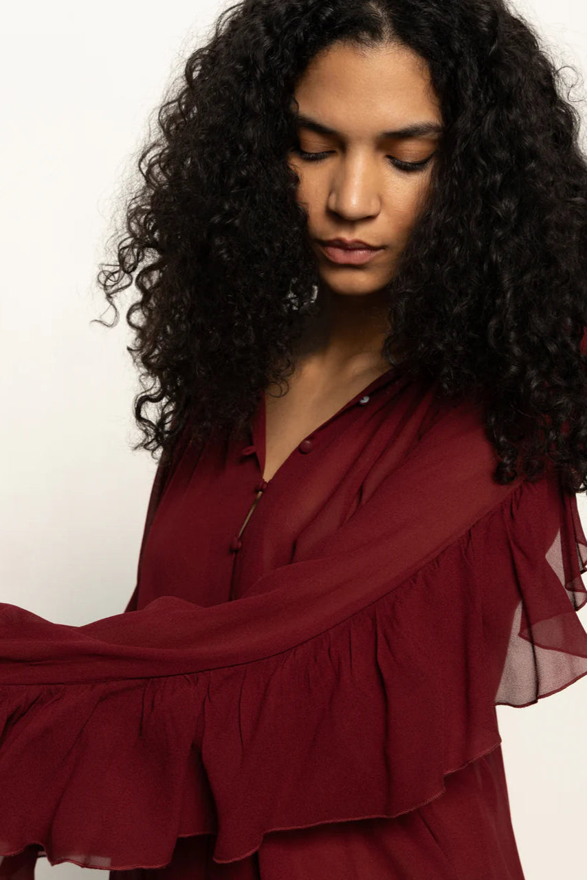 woman wearing a red button front ruffly blouse