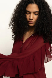 woman wearing a red button front ruffly blouse