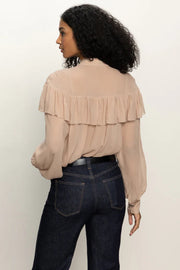 Back view of woman wearing a nude coloured sheer ruffle tie neck blouse