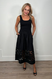 Front view of woman wearing a black cotton dress with cut outs in the bottom