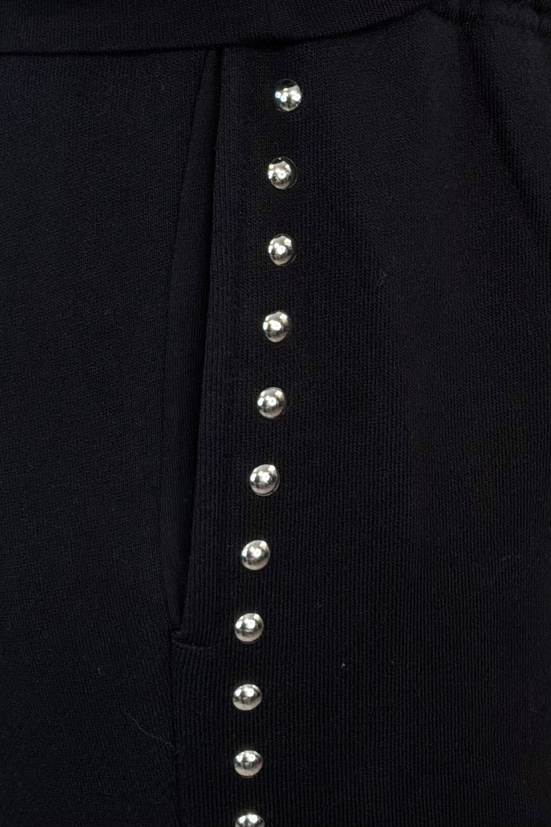 close-up of black pants with studded side panels