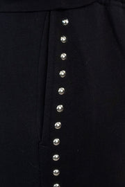 close-up of black pants with studded side panels