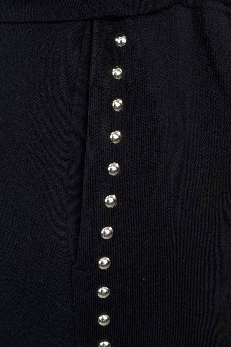 close-up of black pants with studded side panels