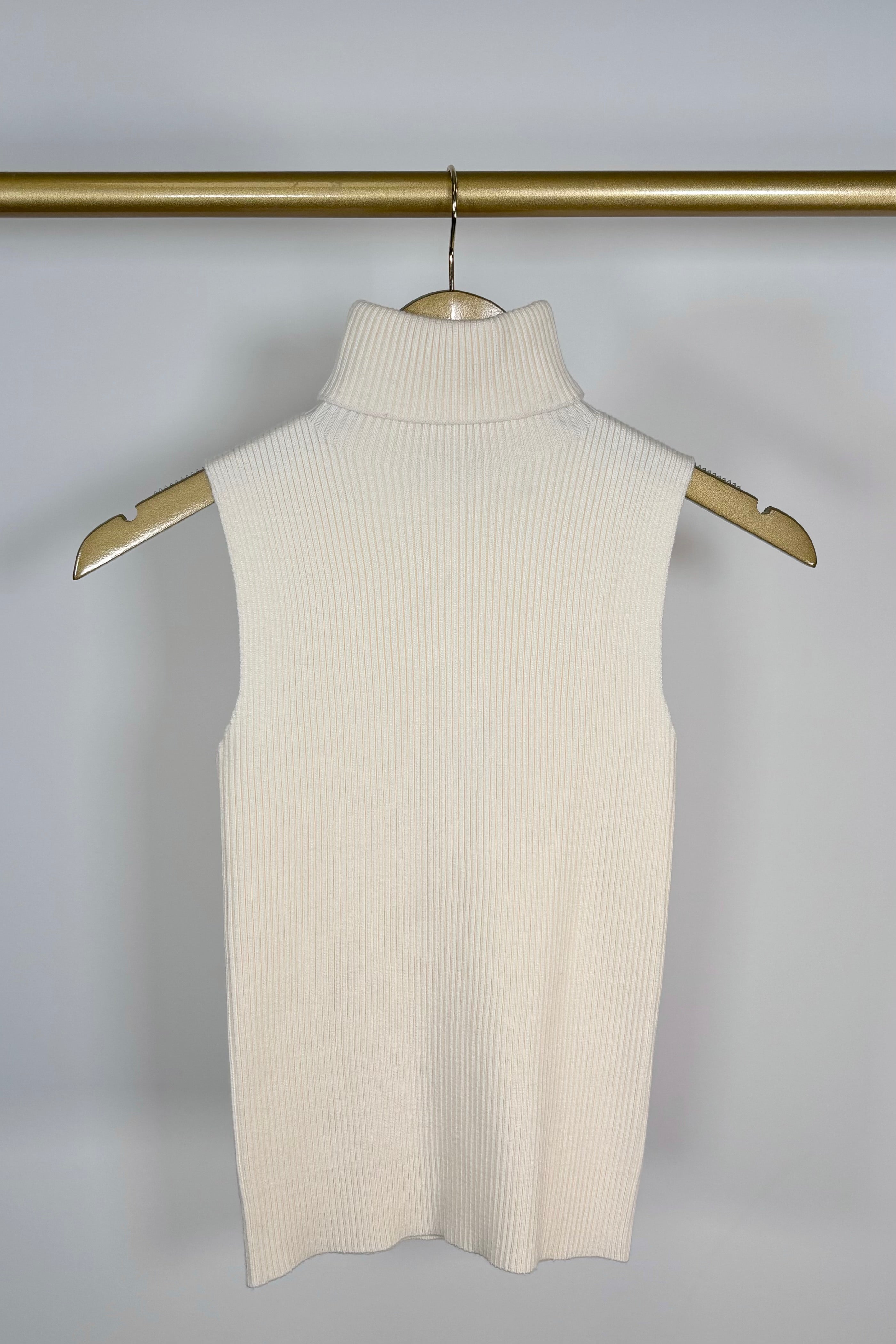 Front view of a cream knitted turtleneck tank top