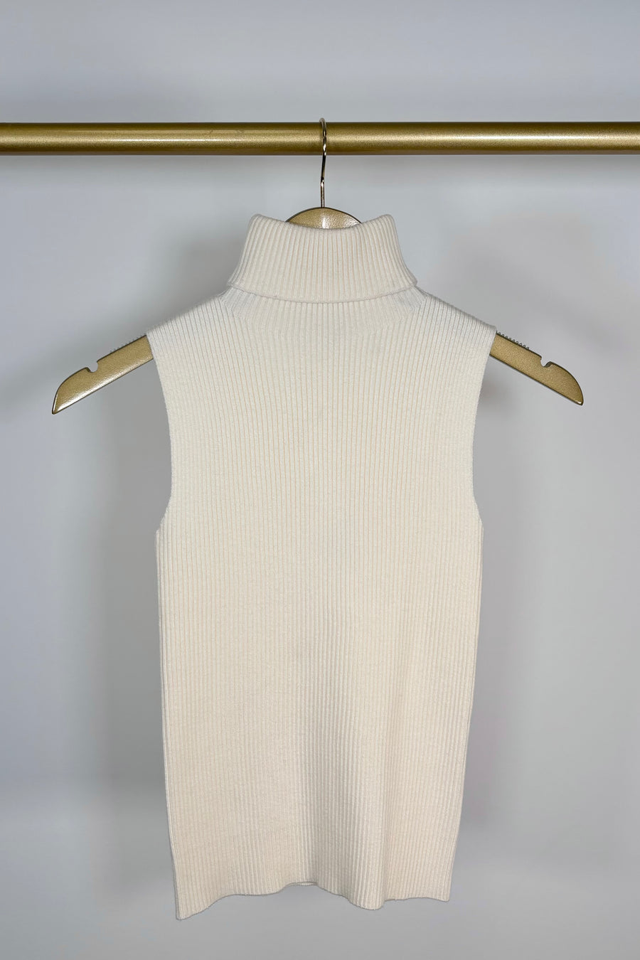 Front view of a cream knitted turtleneck tank top