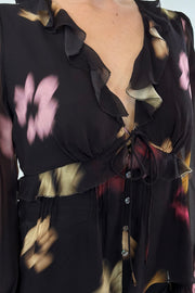 Closeup of Woman wearing a chiffon blouse with floral graphic allover
