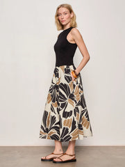 Woman wearing a black midi dress with lotus pattern detail 